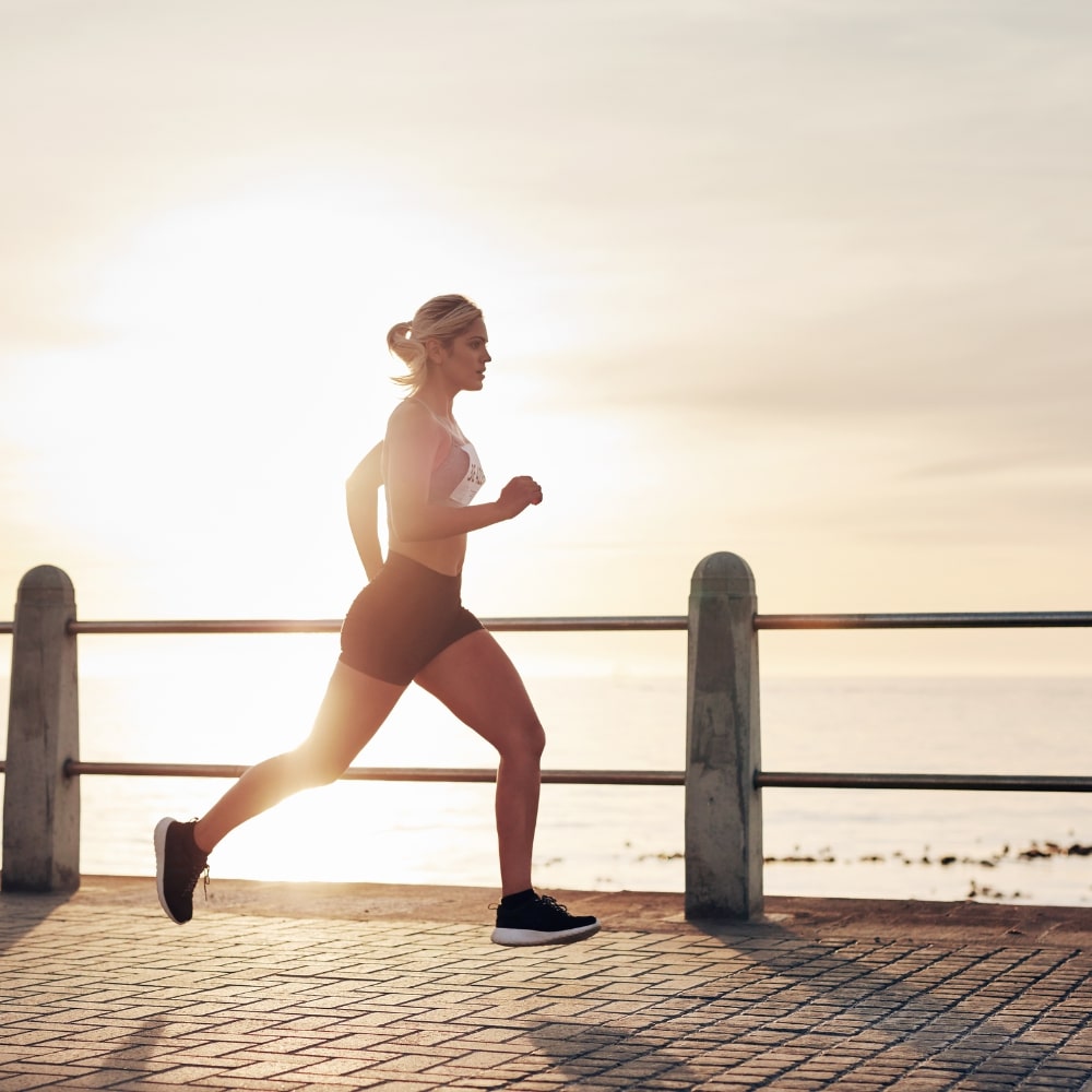Une femme ménopausée fait un footing devant la mer